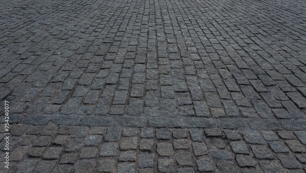 Close up cobblestone pavement, Granite cobblestoned pavement background. Stone pavement texture. Abstract background of cobblestone pavement close up. Seamless texture
