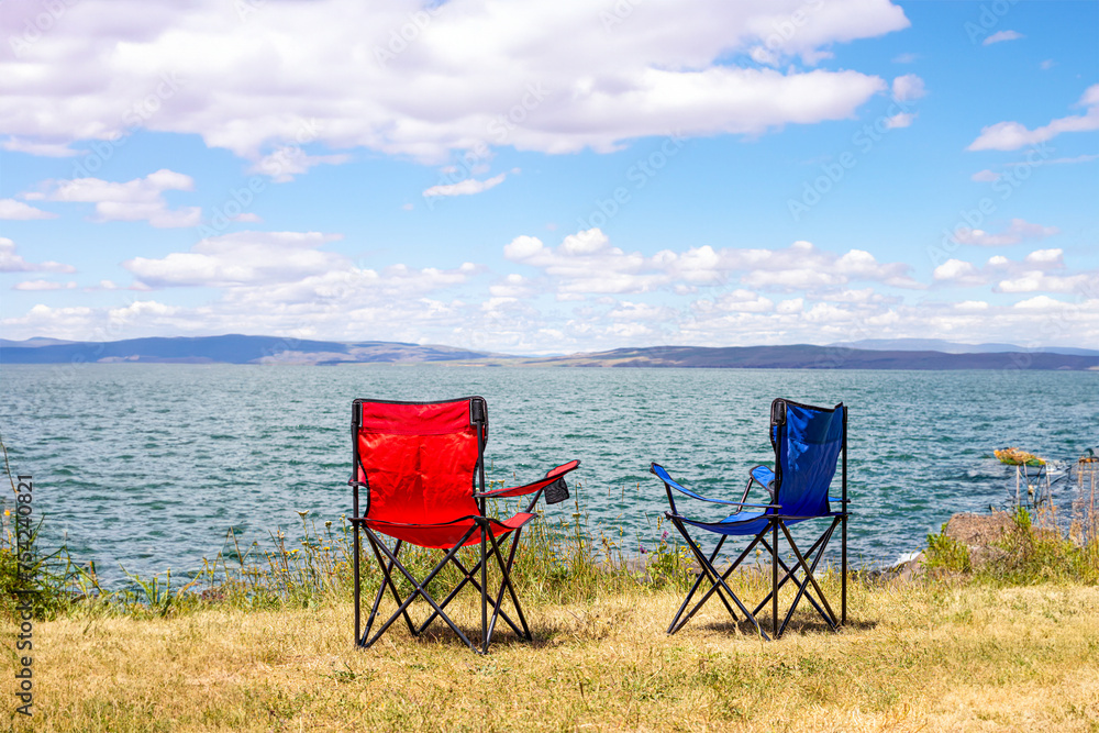 Relaxing summer scene with two empty chairs facing a serene lake. Summer holiday background. Ardahan, Turkey. Relaxing summer scene with two empty chairs facing a serene lake. Summer holiday background. Ardahan, Turkey.
