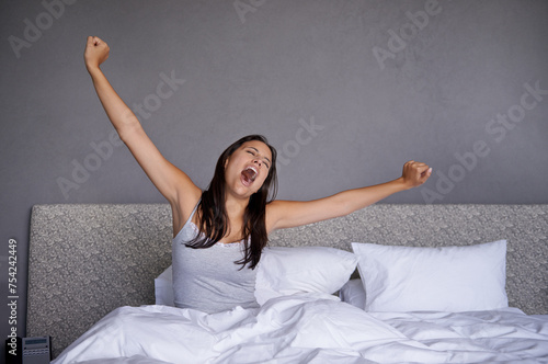 Woman, bedroom and wake up in morning with yawn for routine or fatigue, stretching and sleepy after rest. Female person, home and awake after sleep for wellness, energy and comfort for mental health.