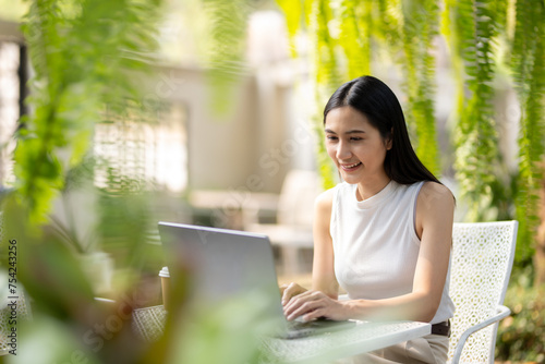 Concentrated young woman working using laptop in bright outdoor park. Free Download Concentrated young woman working using laptop in bright outdoor park. - GFXLoad