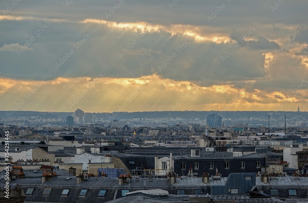 Vue panoramique sur le ciel de Paris en hauteur et rayons du soleil traversant les nuages	