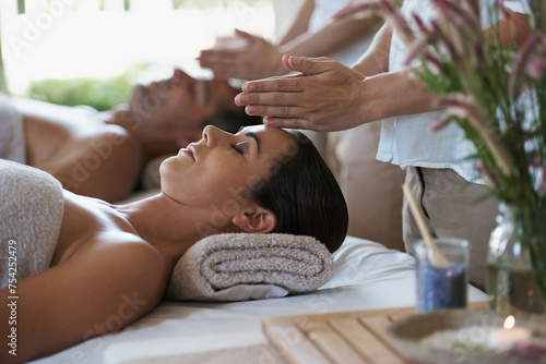 Sleep, head massage and couple relax in spa for care of body with rest on table of retreat for honeymoon. Hotel, man and woman together in resort for health, wellness and luxury for skincare