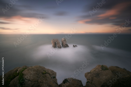 Urro del Manzano in Costa Quebrada, Liencres, Cantabria, on a soft sunset with warm colors in the clouds photo