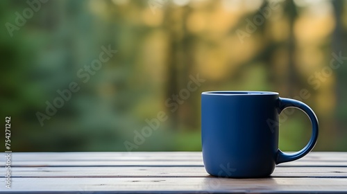 Close up of a navy blue Mug on a wooden Table in a Forest. Blurred natural Background
