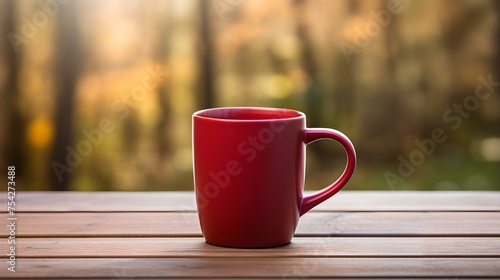 Close up of a ruby Mug on a wooden Table in a Forest. Blurred natural Background
