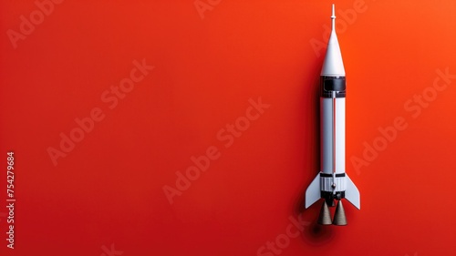White rocket model centered on a vibrant red backdrop