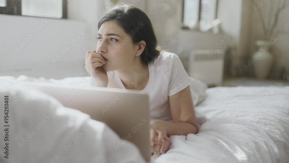 Attractive young woman sitting on bed at home get notification and feeling upset reading bad negative news message on laptop computer indoors Disappointment Fail Unemployment Attractive young woman sitting on bed at home get notification and feeling upset reading bad negative news message on laptop computer indoors Disappointment Fail Unemployment
