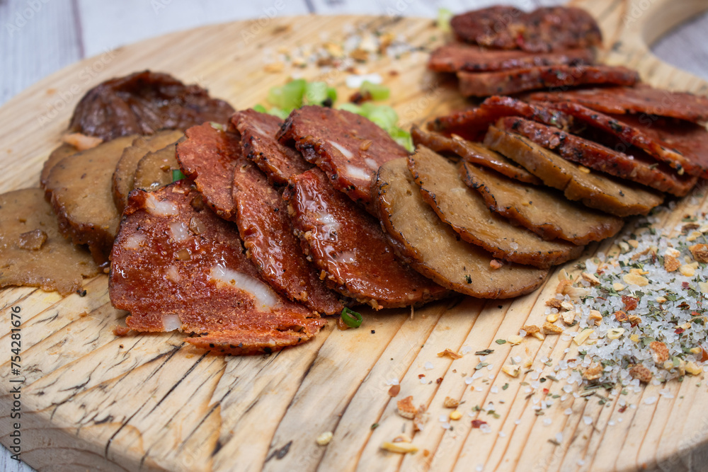 Seitan vegan Ham and Peperoni, plant based. Sliced, on wooden board Seitan vegan Ham and Peperoni, plant based. Sliced, on wooden board
