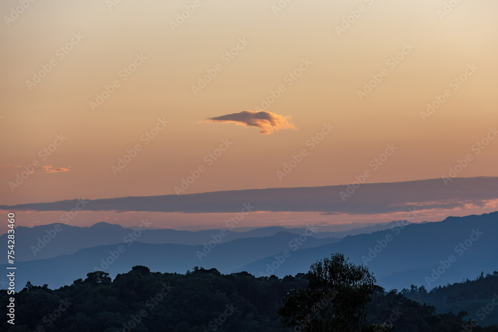 A very little cloud floats at the horizon, in a beautiful dusk over the eastern Andean mountains of central Colombia.