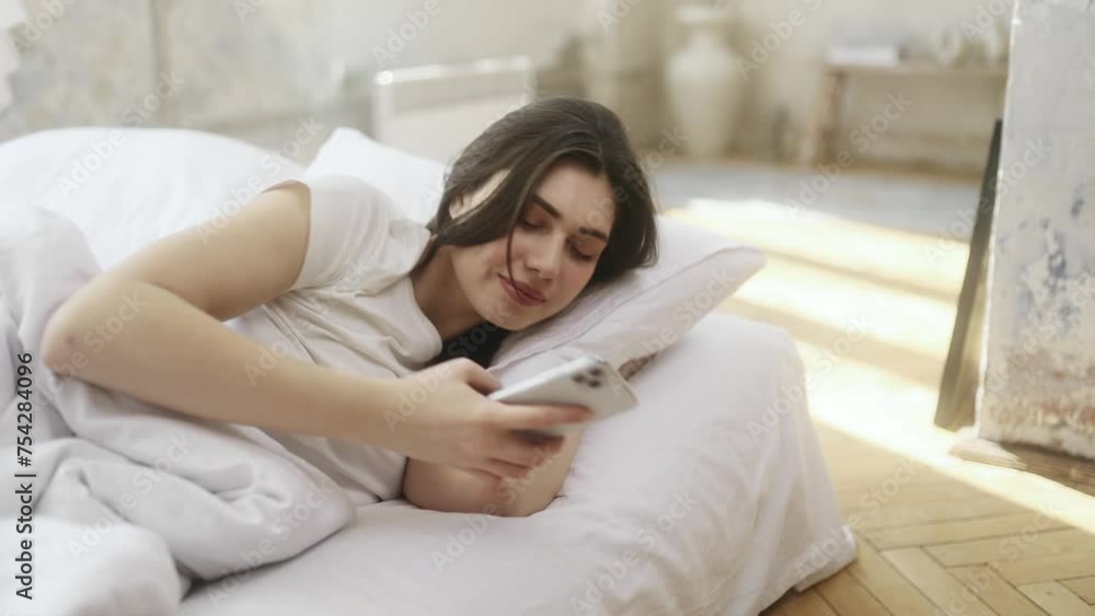 Pretty young woman using smartphone gadget for checking morning news and notifications after wake up on sofa at home Upset female reading negative information on cellphone Bad message concept Pretty young woman using smartphone gadget for checking morning news and notifications after wake up on sofa at home Upset female reading negative information on cellphone Bad message concept