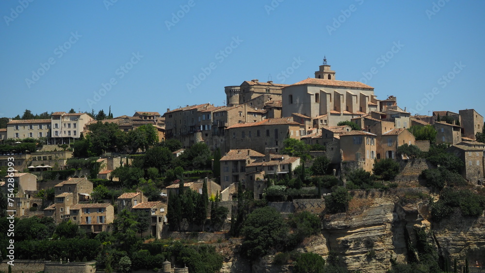 View of Gordes, a typical small town in Provence, France. Beautiful French village with view on roof and landscape on sunny summer day
