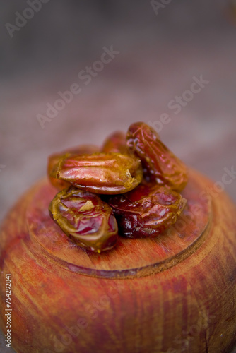 Front view of dried dates or kurma on wooden plate isolated 