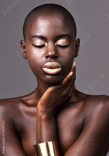 Jewelry, face and skin of black woman for makeup, beauty and cosmetics isolated on gray background. Person, African lady and eyeshadow with lipstick in studio for dermatology, gold head or skincare