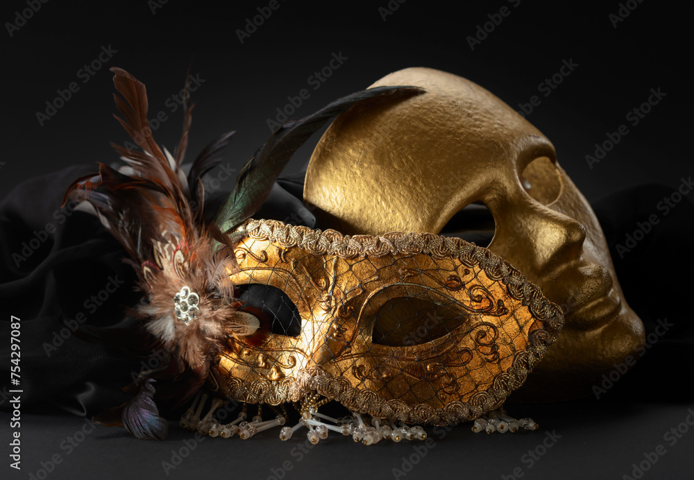 Naklejka premium Golden Venetian carnival masks on a black background.