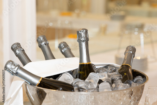 Champagne bottles in container with ice cubes