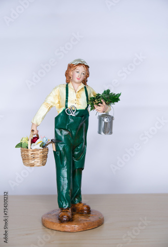 Gardener in uniform, with watering can and basket with flowers