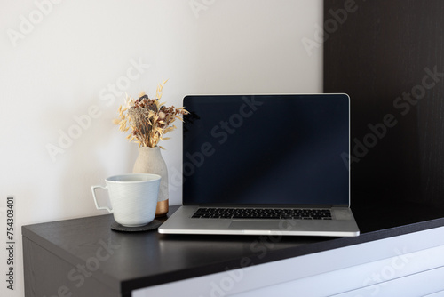 Laptop with smartphone, coffeemug and flowers photo
