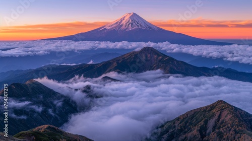  a view of the top of a mountain with clouds in the foreground and a pink sky in the background. © Kaija