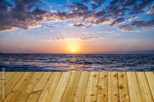 Beautiful sunset over the sea with wooden terrace. Nature composition. can be used for display or montage your products. © nongnuch