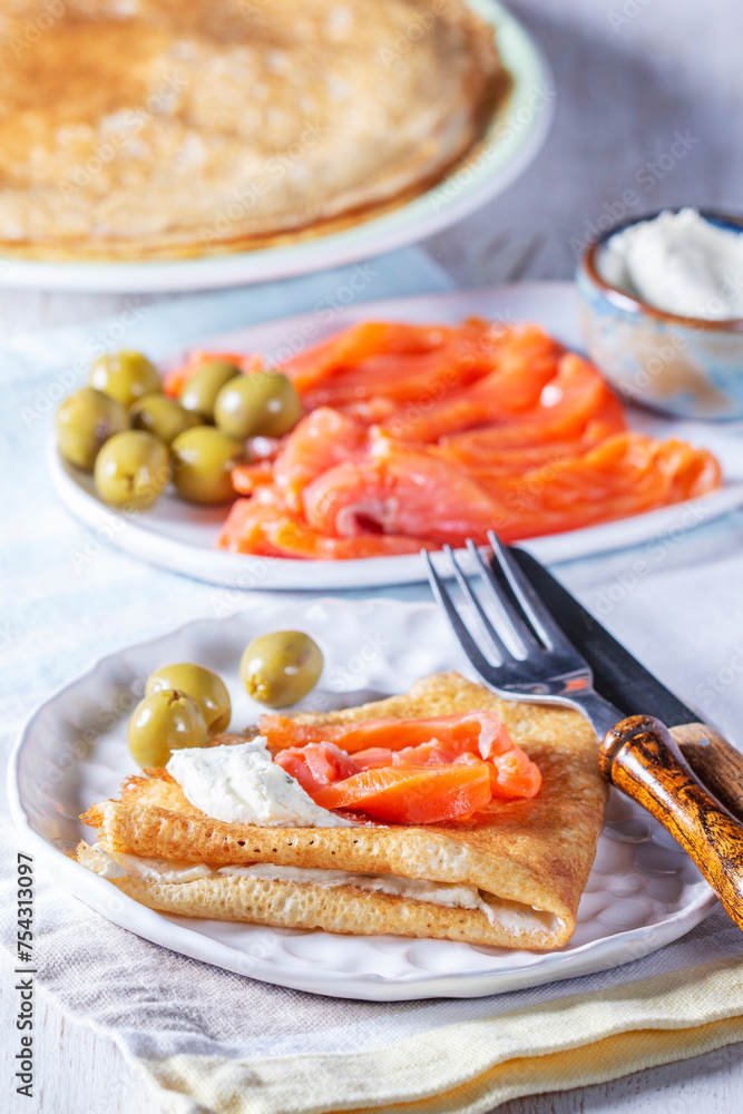 Pancakes with gravlax, cottage cheese and olives. A traditional dish for Maslenitsa or Carnival.