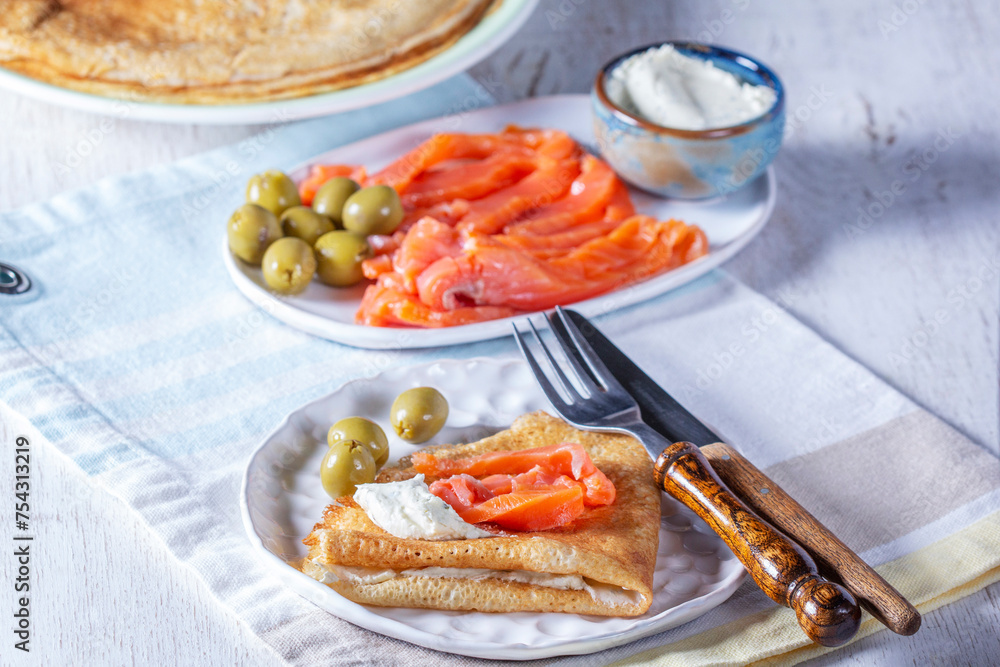 Pancakes with gravlax, cottage cheese and olives. A traditional dish for Maslenitsa or Carnival.