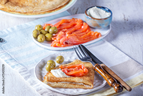 Obraz na płótnie Pancakes with gravlax, cottage cheese and olives. A traditional dish for Maslenitsa or Carnival. w salonie