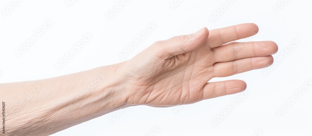 An old caucasian female hand with an opened palm gestures upwards, isolated against a white background. The hand is reaching out towards the sky.
