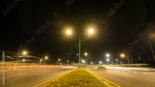 Abstract long exposure dynamic speed lights in the city with beautiful multi-colored lights, modern glitter in the night city on the road, back view. Racing on the field