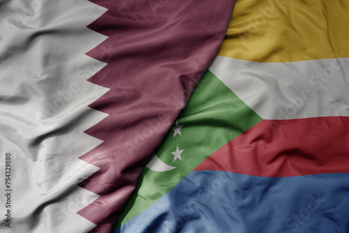 big waving national colorful flag of comoros and national flag of qatar.