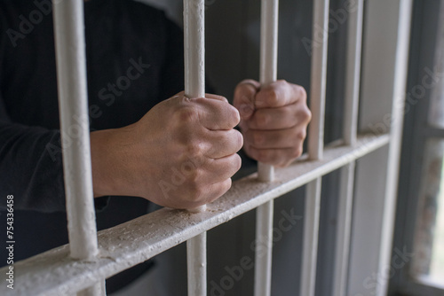 Fotografie 檻に閉じ込められた男性の手　鉄格子を掴む刑務所の犯罪者　Hands of prisoner holding bars in jail