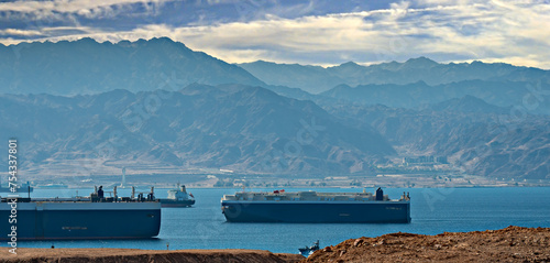 Red Sea, straits and gulfs, surrounding mountains, numerous cargo ships stranded due to Middle Eastern safety concerns in the region