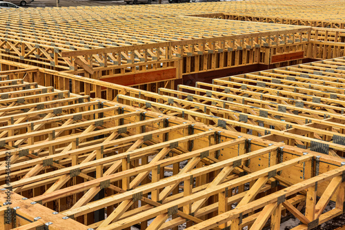 Floor joists at top of first floor ready for second floor construction to begin on multi story wood frame apartment under construction. photo