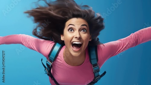 Woman with long hair is jumping in air and smiling photo