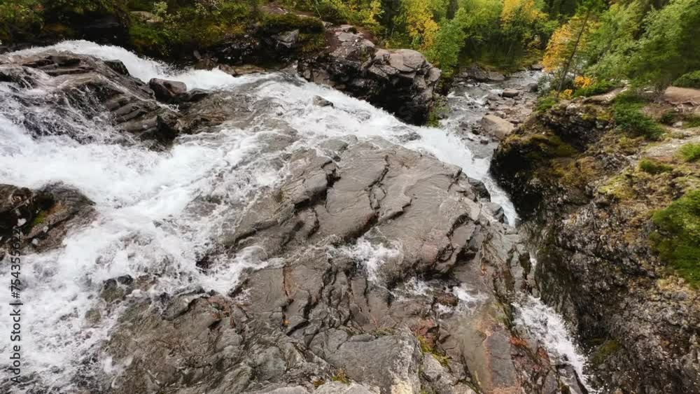 A beautiful waterfall in the autumn mountains beyond the Arctic Circle in the north, in Khibiny, Murmansk region. Panoramic view of a beautiful waterfall in the mountains in autumn, Kola Peninsula 4К A beautiful waterfall in the autumn mountains beyond the Arctic Circle in the north, in Khibiny, Murmansk region. Panoramic view of a beautiful waterfall in the mountains in autumn, Kola Peninsula 4К