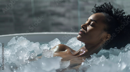 African-american woman ice bathing in the cold water among ice cubes in a tub.  Wim Hof Method, cold therapy, breathing techniques, yoga and meditation. concept cryo therapy. photo