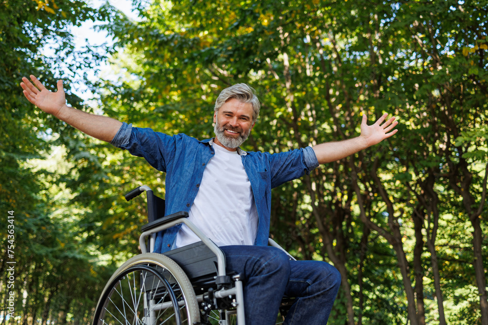 Fototapeta premium Park Pleasures: Man in Wheelchair Engaging with Open Arms