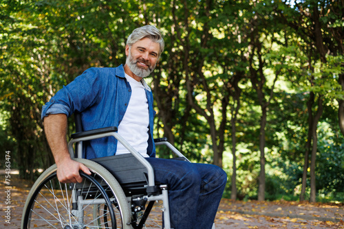 Overcoming Obstacles: Man Striving to Stand in Wheelchair © Andrii 