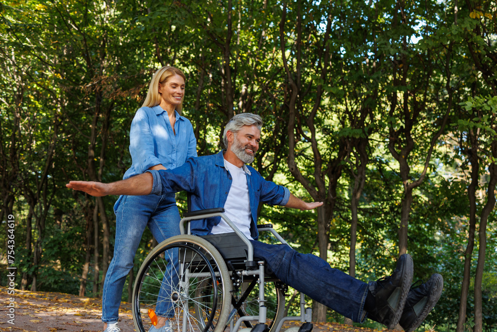 Woman Helps Masked Man in Wheelchair Navigate Park Woman Helps Masked Man in Wheelchair Navigate Park