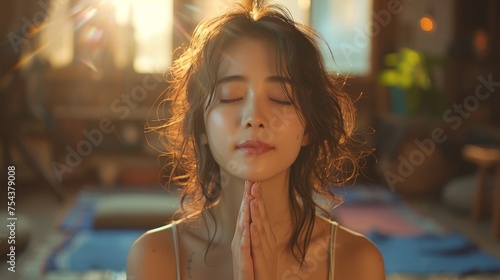 Make a wish, asian young woman prays, sitting meditating at home, praying to God with closed eyes with closed eyes with prayer, thank you God for your help.