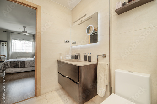 Small bathroom with porcelain toilets, dark cabinet with drawers, mirror with USB lights and shower cabin with tempered glass screens