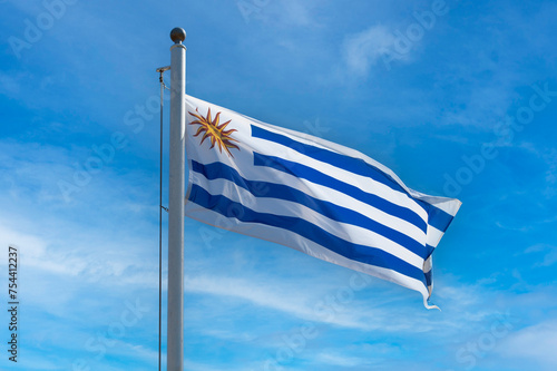 Uruguay flag on a flagpole against the blue sky