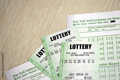 Green lottery tickets and blank bills with numbers for playing lottery close up