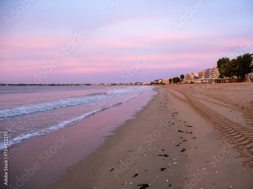 La Baule-Escoublac, France. Amazing view of the sunrise with clouds in the colors of pink and purple. Sea waves along the seashore at sunrise. Morning time. Ocean view photo