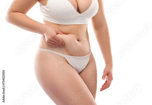 The girl stretches the skin on the leg and on the stomach, showing fat deposits. Treatment and getting rid of excess weight, the deposition of subcutaneous fat.