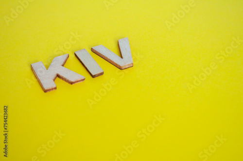 KIV wooden letters representing Keep In View on yellow background photo