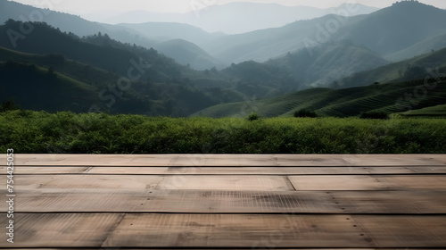 a wooden deck with tea fields and mountains behind it