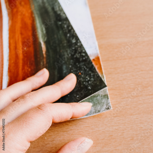 Close up of hand holding canvas fine art print abstract art blank clean wood background