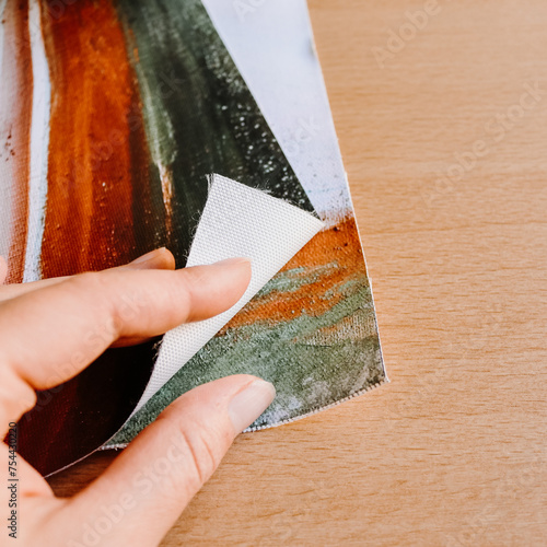Close up of hand holding canvas fine art print abstract art blank clean wood background