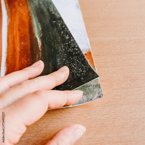 Close up of hand holding canvas fine art print abstract art blank clean wood background