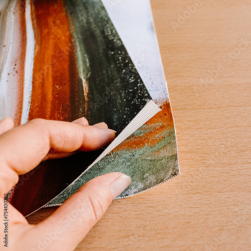 Close up of hand holding canvas fine art print abstract art blank clean wood background